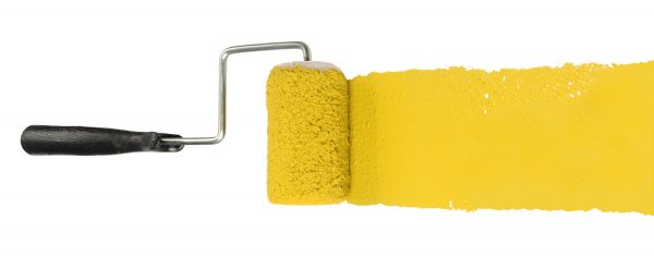 Paint roller with yellow pigment isolated over white background